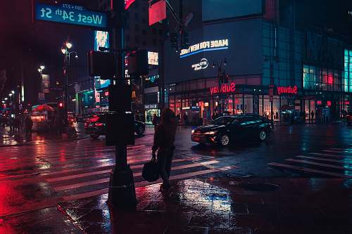 city person standing beside traffic light during night urban